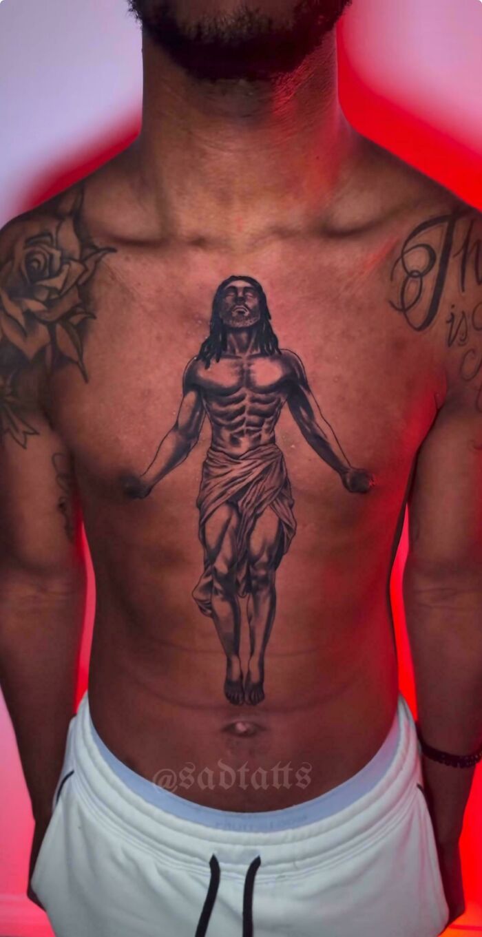 Chest tattoo of a muscular Jesus figure missing hands, a funny example of awful taste but great e*******n tattoo art.