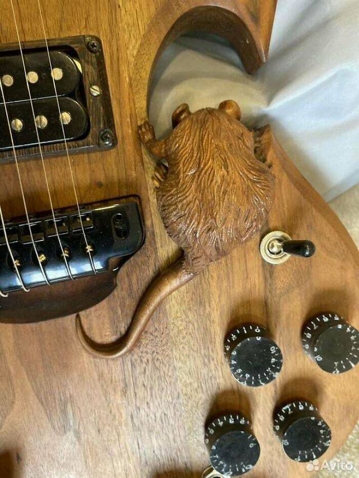 Electric guitar with a wooden rat sculpture integrated near the knobs, an example of awful taste but great e*******n design.