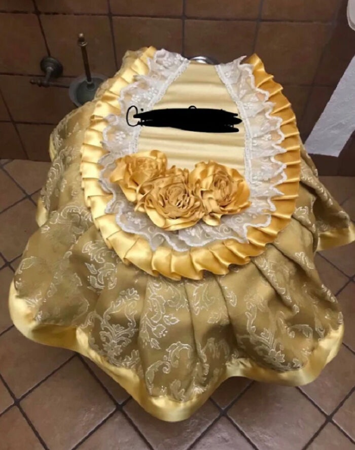 Decorative fabric cover with satin roses and lace, an example of awful taste but great e*******n in design.