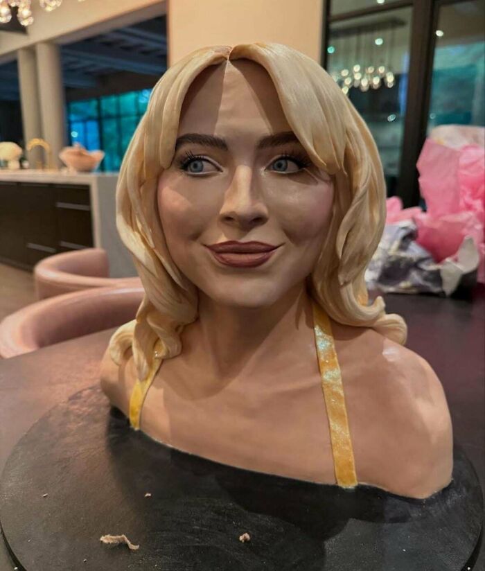 Realistic bust sculpture of a blonde woman showing examples of awful taste but great e*******n in art and design.