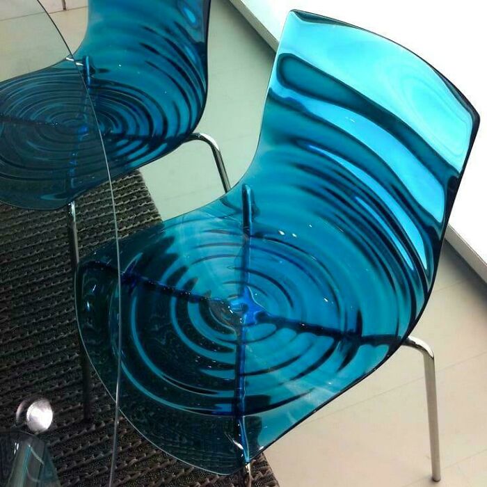 Blue transparent designer chairs with ripple patterns enhancing the smart and cool interior design concept.