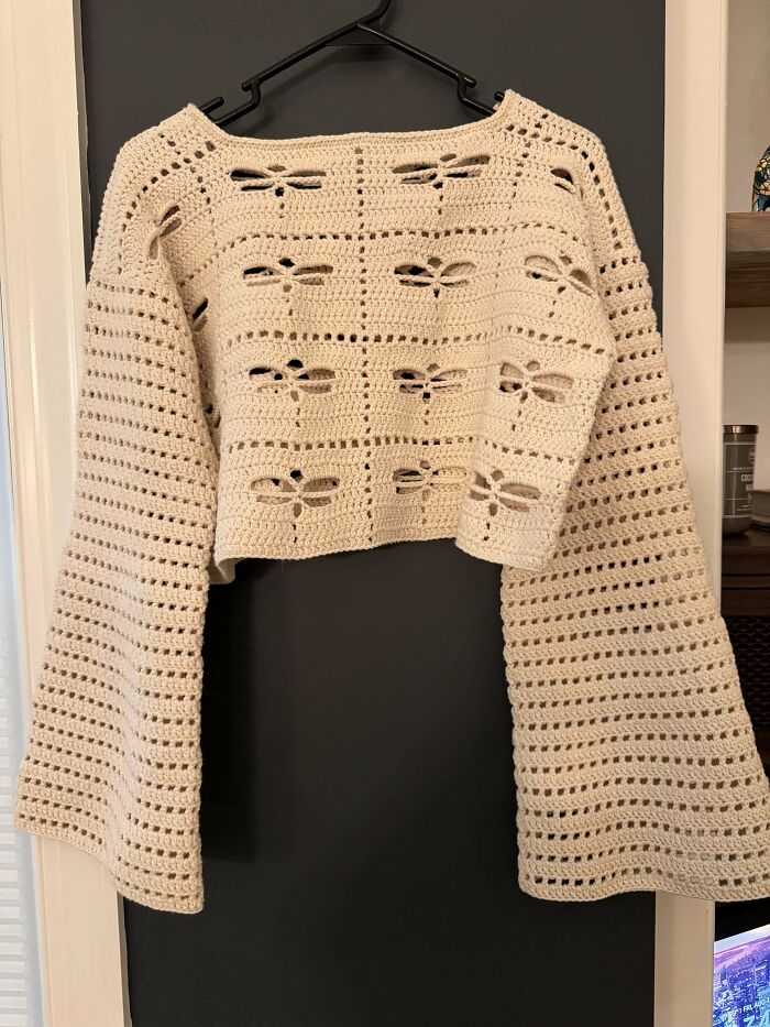 Cream crochet sweater with dragonfly patterns and wide sleeves, showcasing an impressive handmade crochet creation.