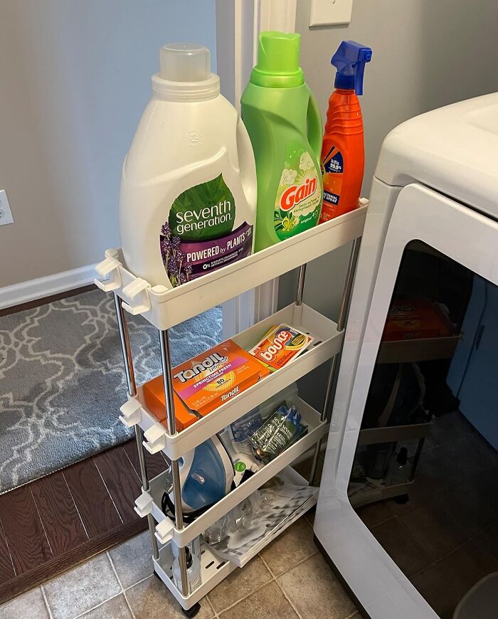 Compact multi-tier rolling cart neatly organizing laundry supplies in a small apartment space for efficient furniture storage.