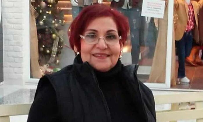 Mujer de cabello rojo y gafas sonriendo en centro comercial con decoración y escaparate, datos e historias interesantes.
