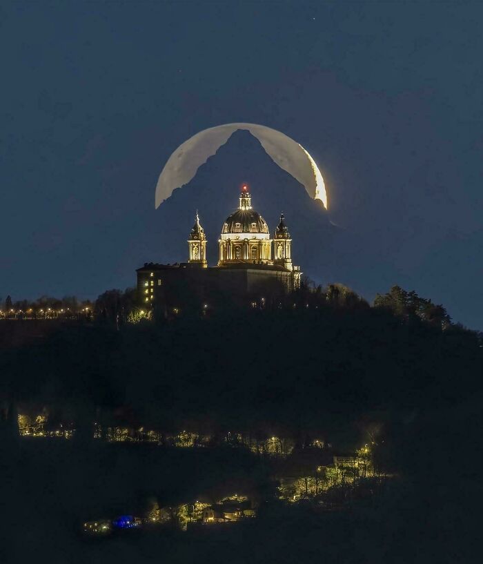 Basílica iluminada de noche con la luna llena detrás, imagen que ilustra datos e historias interesantes del mundo.