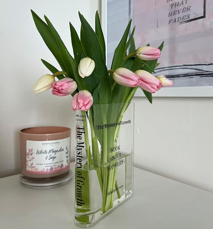 Clear vase with pink and white tulips next to a scented candle, a thoughtful gift for someone barely holding it together.