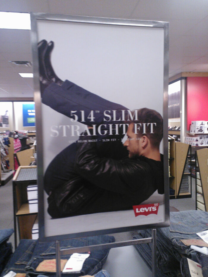 Levi's advertisement showing an unattainable slim body pose for 514 slim straight fit jeans in a retail store.