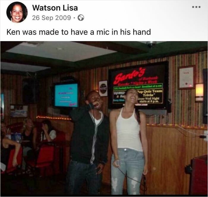 Two people smiling and holding a microphone in a dimly lit bar, showcasing aged like wine moments of accurate predictions.