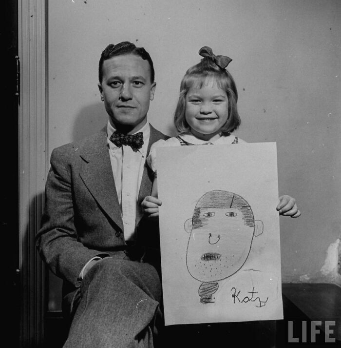 A young girl in 1949 proudly holding her humorous drawing of her dad from memory, sitting next to him in a black and white photo.