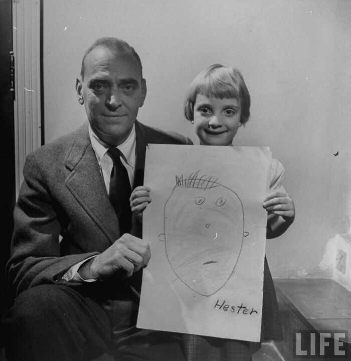 Child proudly holding a drawing of her dad from memory in 1949, showing one of the kids’ hilarious dad portraits.