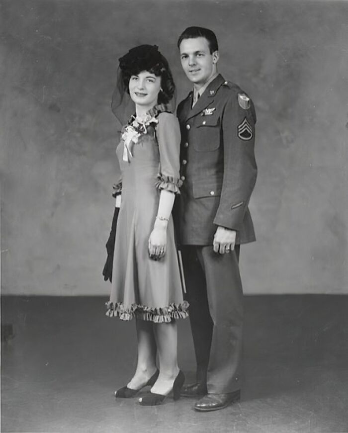 1940s wedding photo of couple with groom in military uniform and bride in vintage dress and hat showing love in the shadow of war.