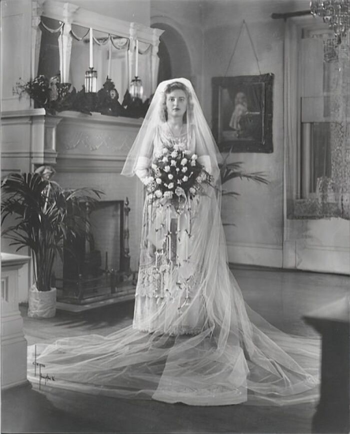 Bride in a 1940s wedding dress holding a bouquet, captured in a moving wedding photo from the love in the shadow of war era.