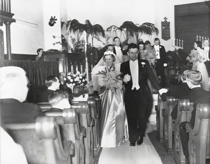 Bride and groom walking down the aisle in a moving 1940s wedding photo capturing love in the shadow of war.