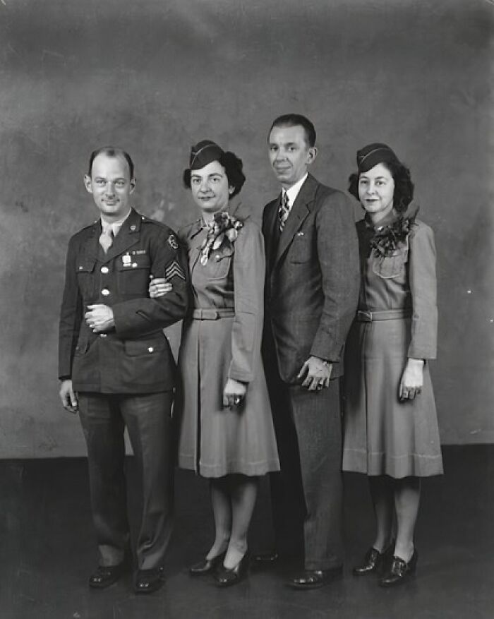 Black and white 1940s wedding photo showing couples with military attire and vintage dresses capturing love in the shadow of war.