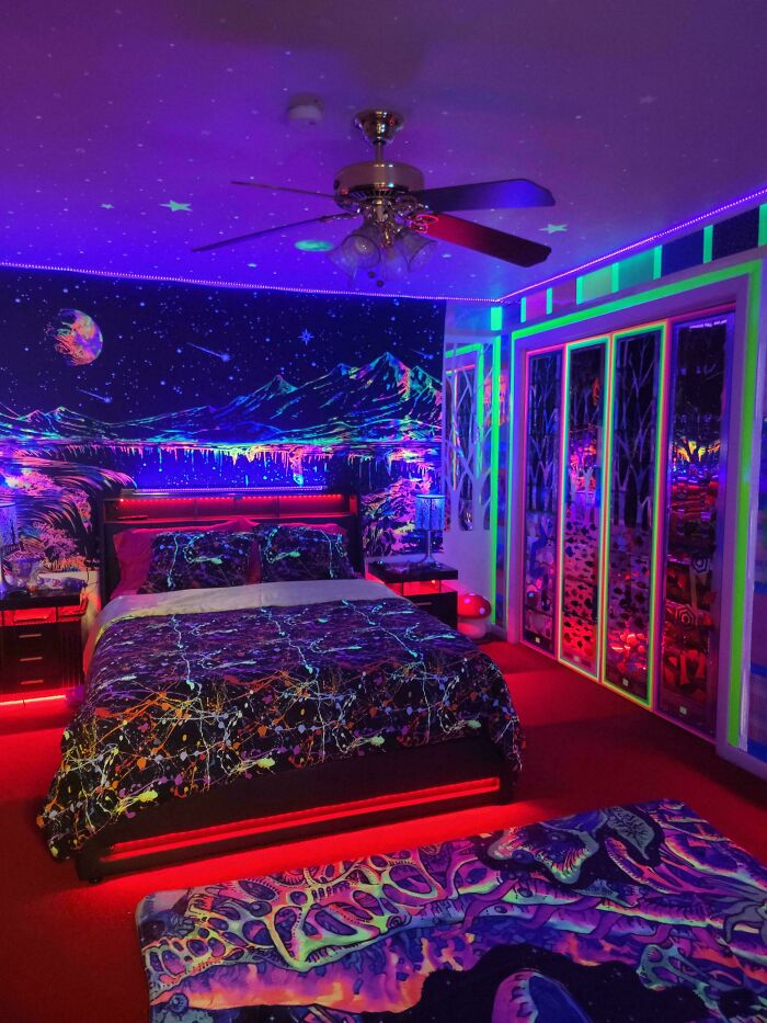 Vibrant bedroom corner decorated with neon lights, cosmic wall art, and colorful bedding showcasing creative home decorating pride.