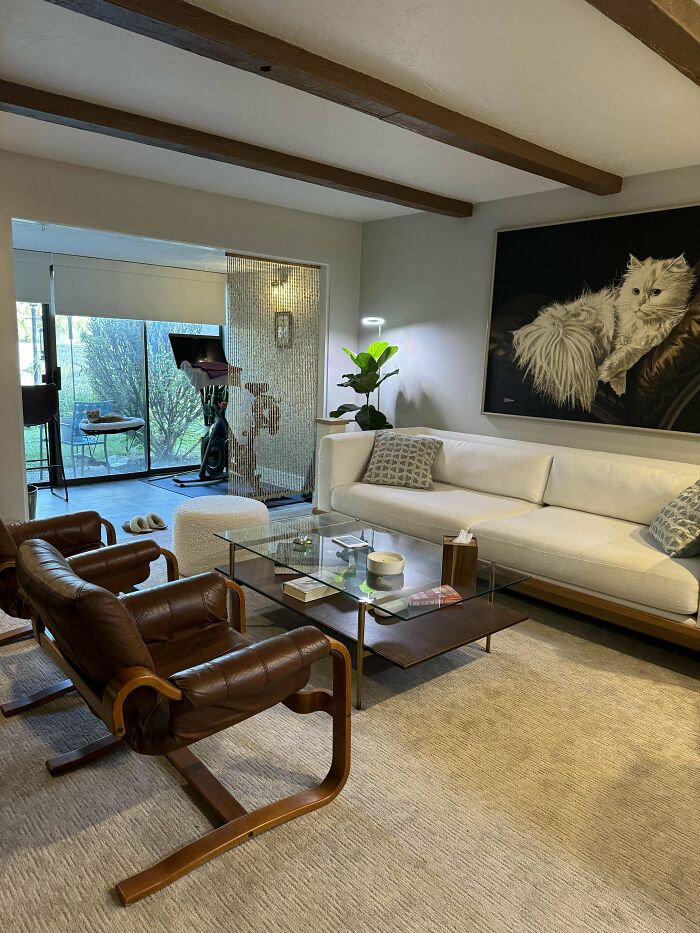 Cozy living room corner with leather chairs, white sofa, glass coffee table, and modern decor showing home decorating pride.