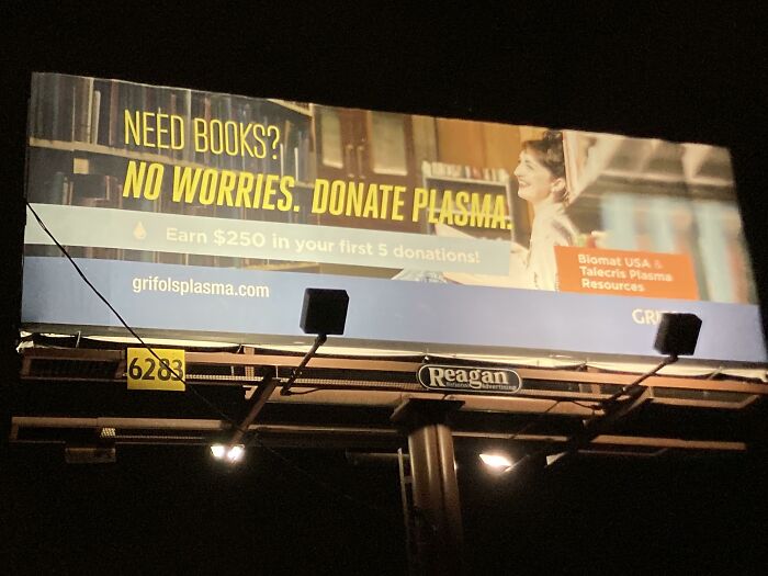 Billboard at night promoting plasma donation as a solution, reflecting photos that make you wonder about the point of no return.