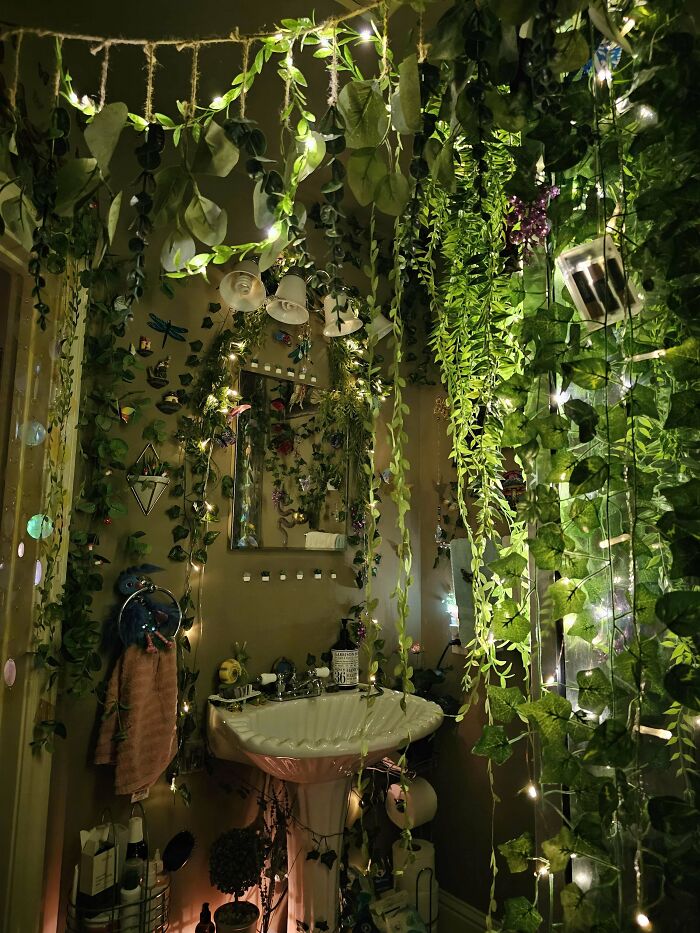 Cozy bathroom corner decorated with hanging greenery and string lights, a home decor people feel proud of.
