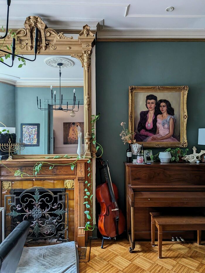 Cozy decorated home corner with vintage piano, cello, ornate mirror, green walls, and framed portrait art showcasing proud decorating.