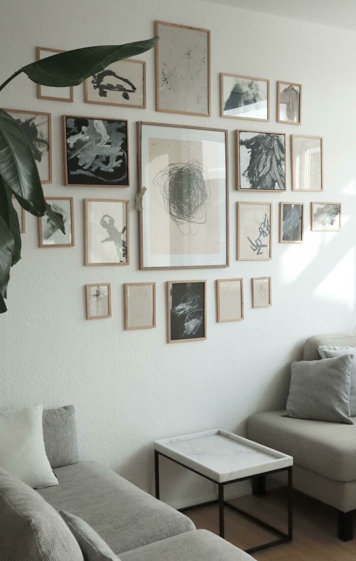 Cozy living room corner with modern abstract art wall decor and neutral-toned furniture showcasing proud home decorating.