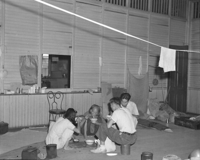 Group of soldiers eating a meal inside a temporary shelter in a rare WWII photo showing wartime daily life moments.