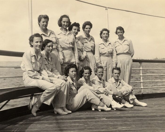 Group of women in uniform posing on a ship deck in a rare WWII photo, showcasing historical military service.