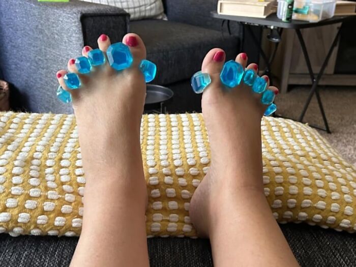 Feet with bright blue toe separators resting on a textured yellow and white cushion, showcasing brilliant Amazon finds.