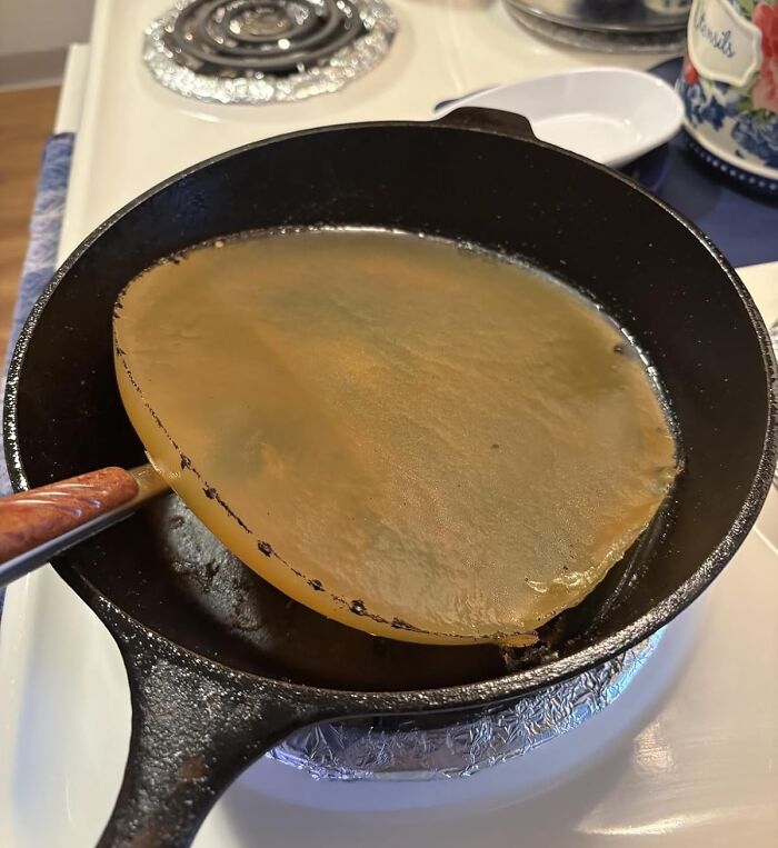 Cast iron skillet with a cooking tool lifting a flat, golden brown food item on a stovetop, Amazon finds for kitchen use.