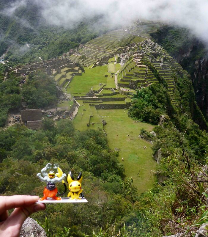 Hand holding funny toy figures in front of ancient ruins, a vacation pic perfect for a comedy special moment.