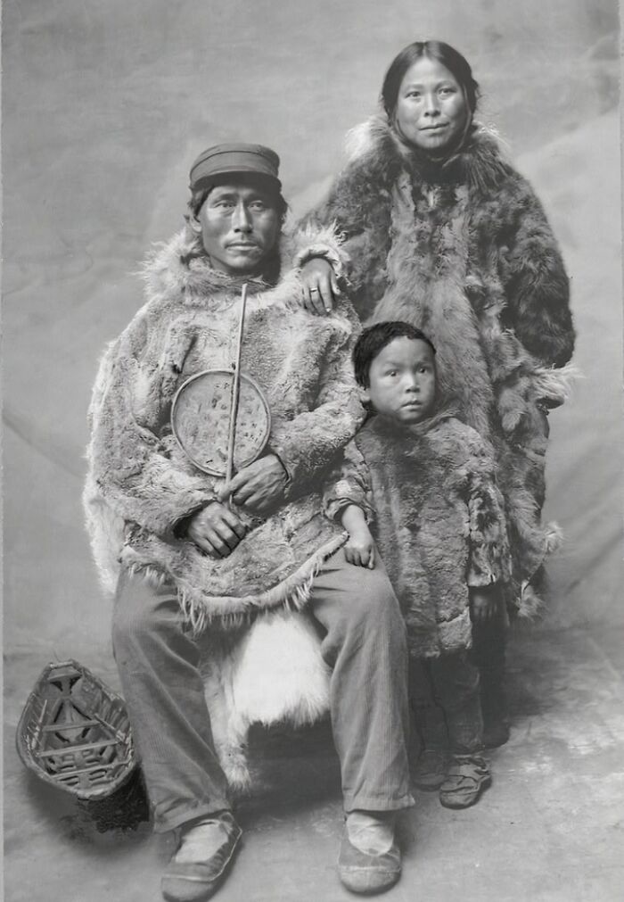 Historic black and white photo of an Inuit family wearing traditional fur clothing, capturing the spirit of the Inuit culture.