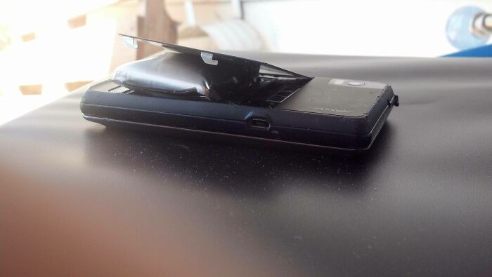 Teléfono móvil con batería abultada y dañada, mostrando daños por las consecuencias de las olas de calor veraniegas.