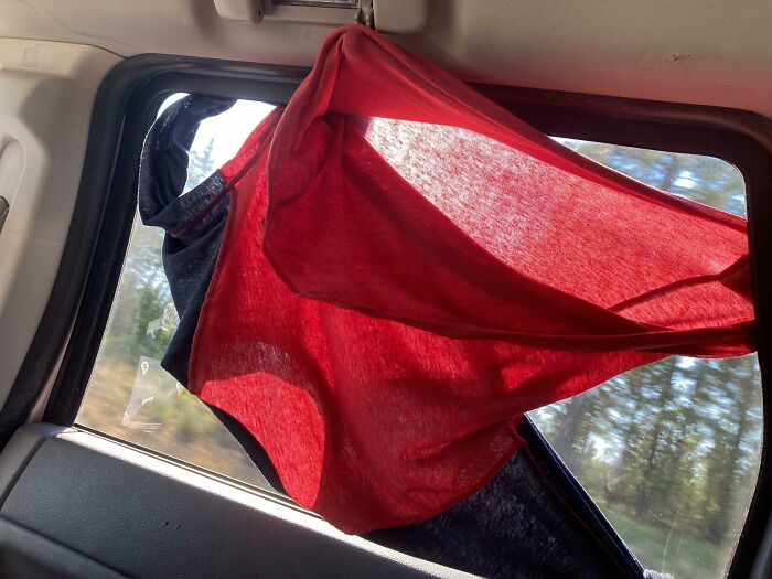Clothes hanging on a car window to block sunlight, illustrating the hot mess caused by this year's heatwaves worldwide.