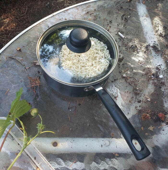 Pot on a glass table with uncooked noodles showing the hot mess caused by this year's heatwaves worldwide.