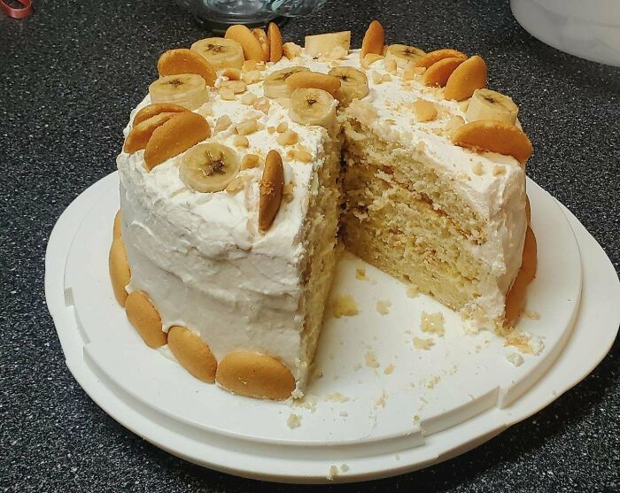 Banana pudding layered cake with vanilla wafers and whipped frosting, showcasing gorgeous baked goods in a home kitchen setting.