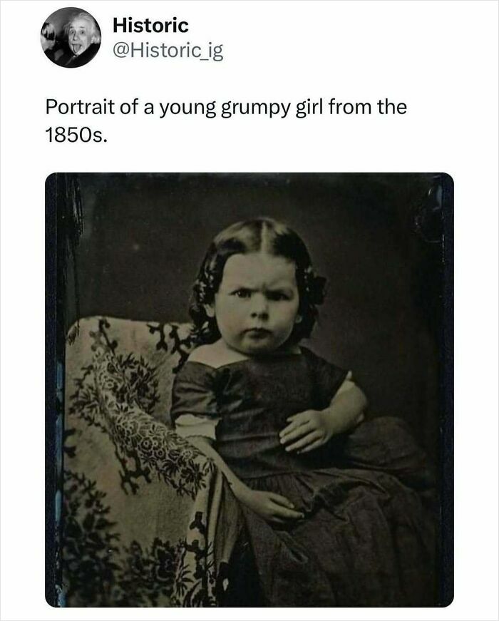 Young grumpy girl from the 1850s sitting on a patterned chair in an interesting historic photo.
