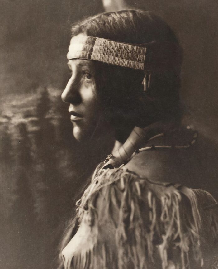 Native tribes member in traditional clothing and headband, captured with strength and dignity in early 1900s photography.