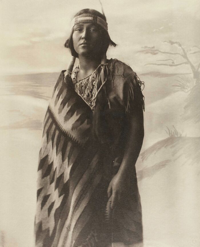 Native tribes member in traditional clothing and headband, showcasing the strength and heritage captured by early 1900s photography.