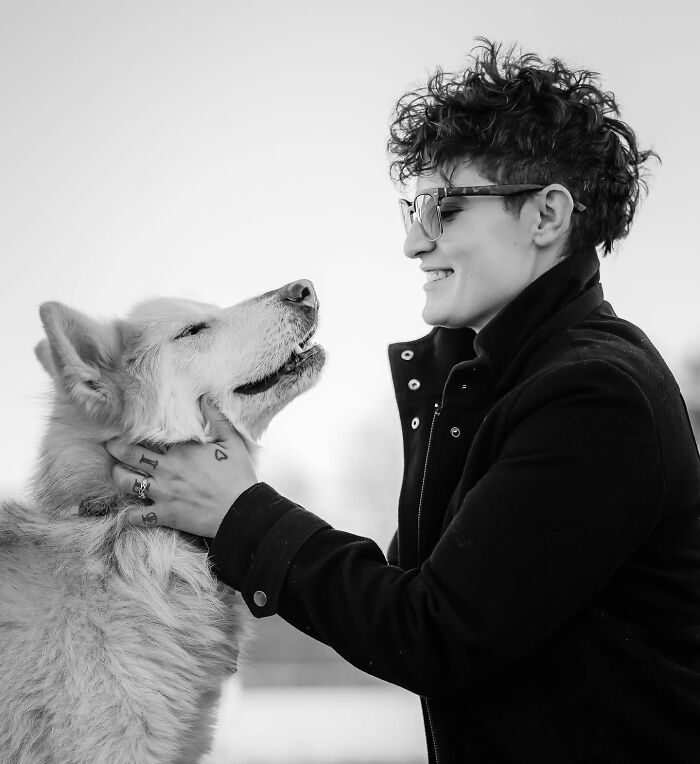 Person with short curly hair and glasses sharing a tender moment with a dog in touching photos capturing final moments between pets and humans