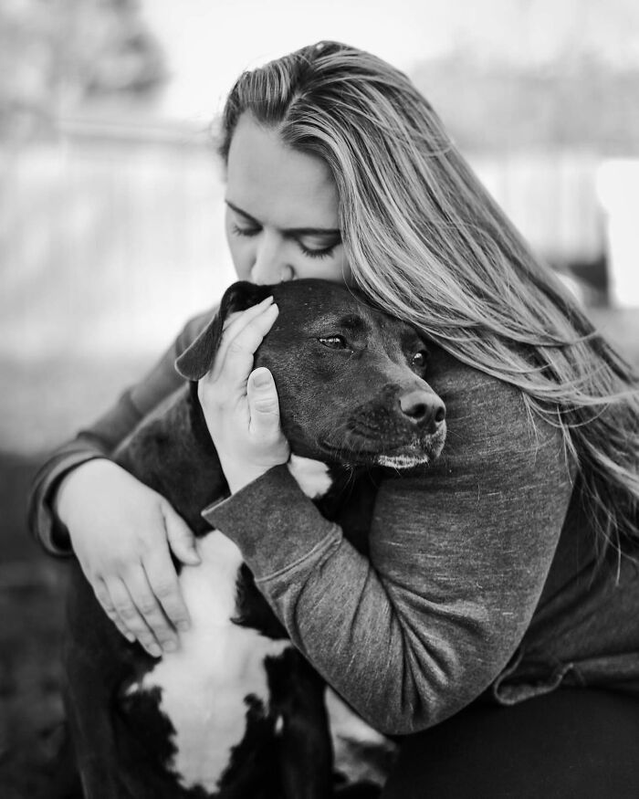 Woman embracing and kissing her dog, capturing a touching final moment between pets and their humans.