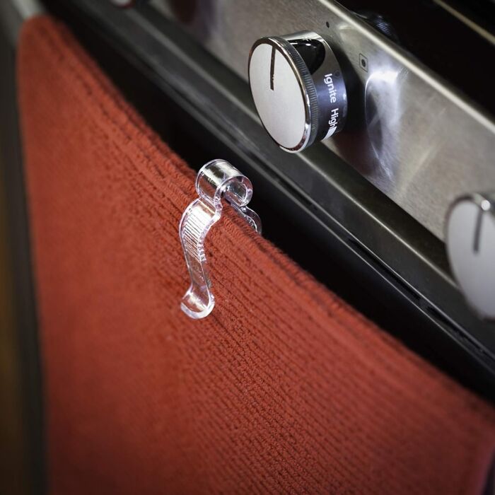 Clear plastic towel holder clip attached to oven handle, a clever find for daily annoyances under $20.