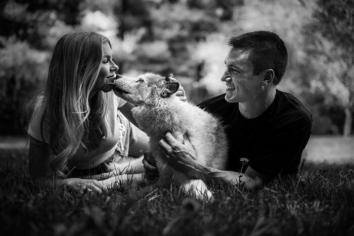 Couple sharing a tender moment with their dog, capturing touching final moments between pets and their humans outdoors.