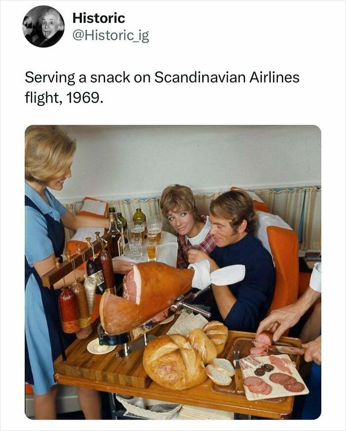 Flight attendant serving meat and bread snacks to passengers on a Scandinavian Airlines historic flight in 1969.