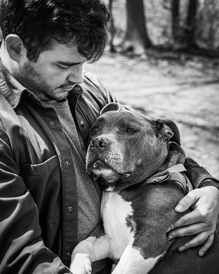 Man embracing his dog outdoors, capturing a touching moment between pets and their humans in a heartfelt scene.