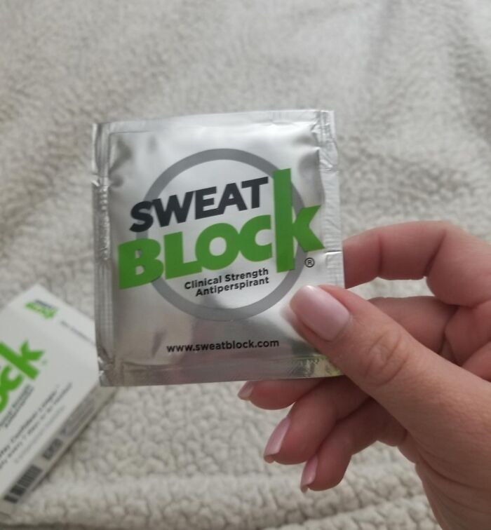 Hand holding a SweatBlock clinical strength antiperspirant packet for heatwave hacks to stay cool.