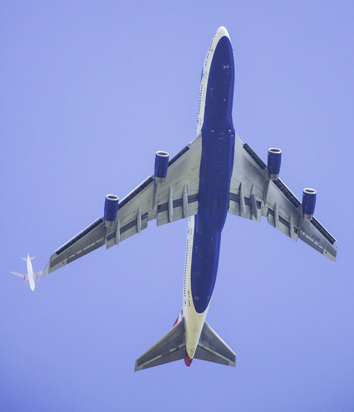 Large commercial airplane flying overhead with a smaller plane in the distance showing rare coincidences in photography.