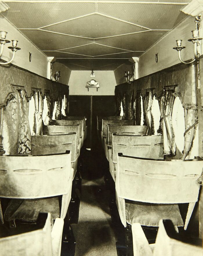 Vintage airplane interior with plush seating and decorative curtains showcasing flying glamour from a bygone era.