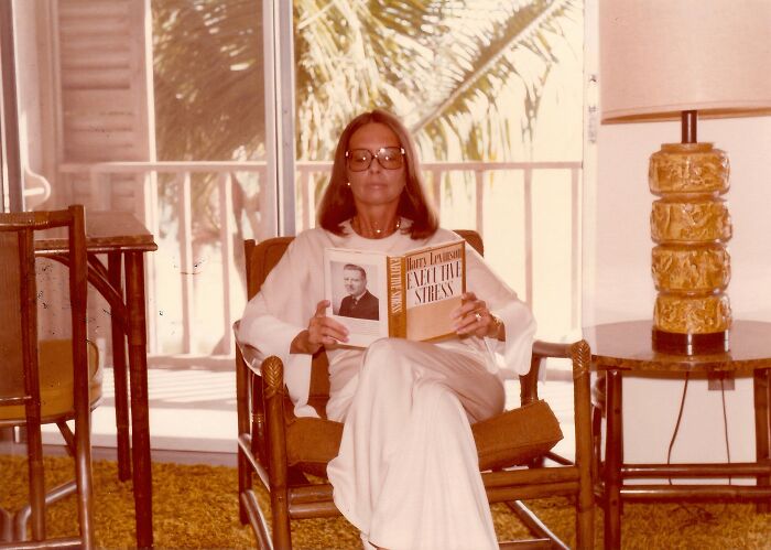 Woman in Florida reading a book while seated, showcasing 1970s style and breaking barriers in the era.