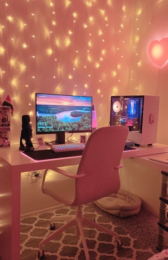 Cozy dorm room setup with a computer desk, gaming PC, chair, and string lights to survive freshman year dorm finds.