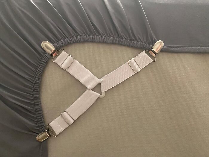 Elastic bed sheet straps securing fitted sheets on a dorm mattress to help survive freshman year with genius dorm finds.