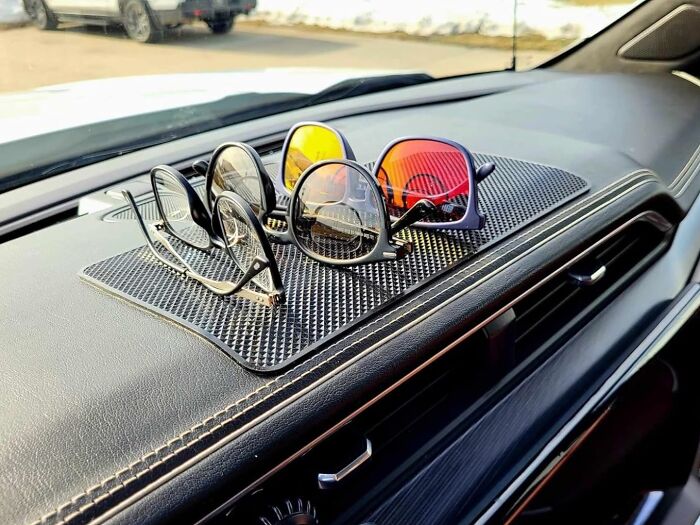 Non-slip car dashboard gadget holding multiple pairs of glasses, solving everyday storage problems efficiently.